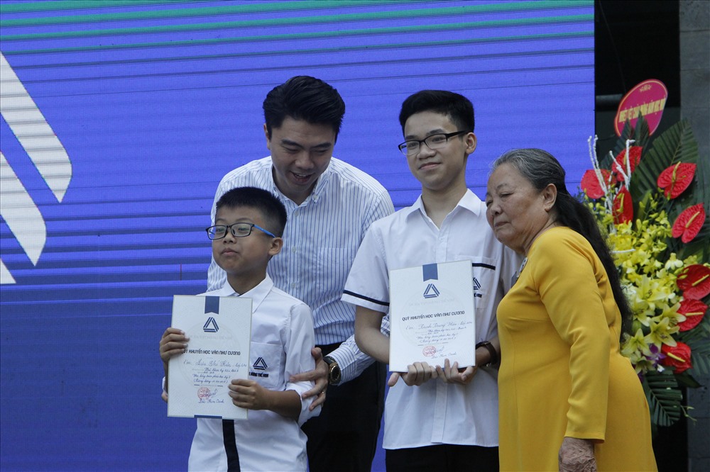 Vợ của nhà giáo Văn Cương trao học bổng cho các em học sinh có thành tích xuất sắc. Ảnh: Nguyễn Hà