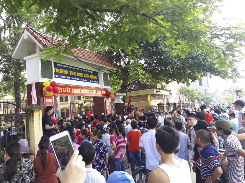 Rất đông phụ huynh theo dõi lễ khai giảng của học sinh qua cánh cổng trường. Ảnh Trần Vương