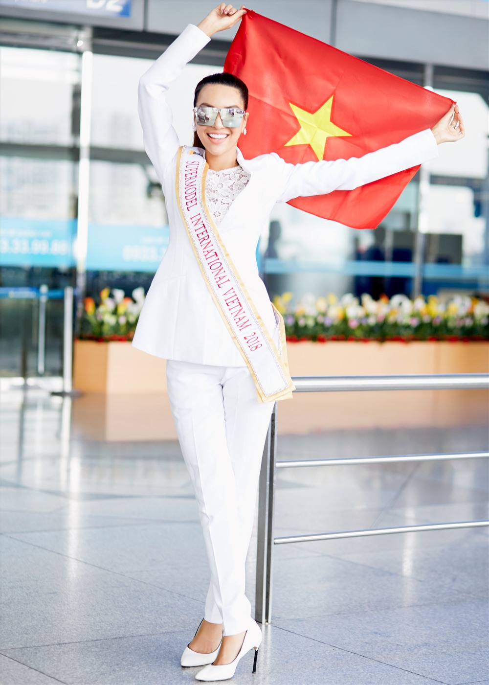 Khả Trang thể hiện sự tự tin khi cầm Quốc Kỳ Việt Nam giương cao tại sân bay. 