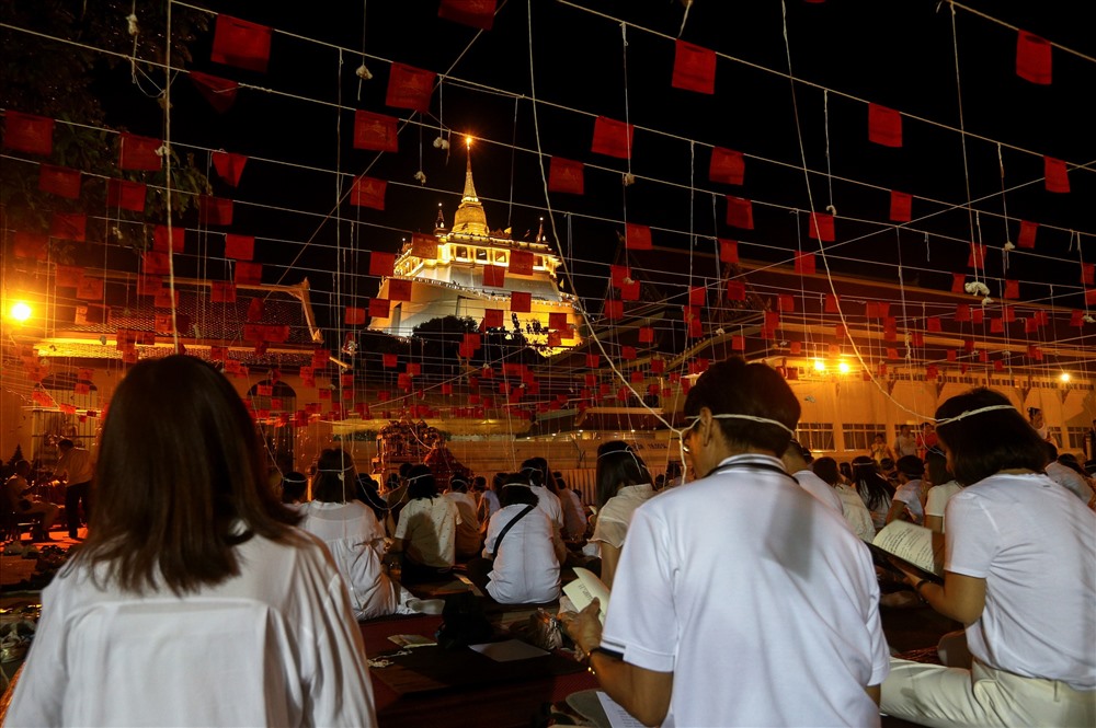 Tại Thái Lan, người dân có những cách đón năm mới rất đặc biệt. Nhiều tín đồ Phật giáo tập trung tại Chùa Vàng ở Bangkok để cầu nguyện bình an trong năm mới. Những sợi dây buộc trên đầu là một phần nghi lễ cầu nguyện. Ảnh: Reuters.