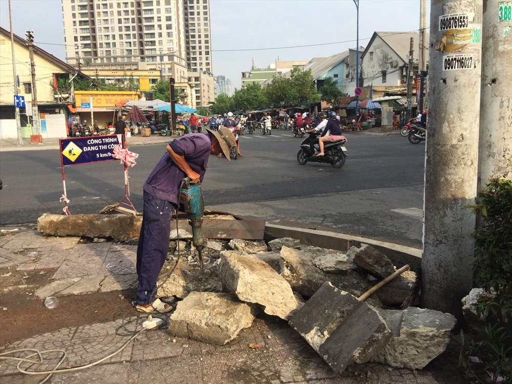 Công nhân thi công lát lại gạch vỉa hè và mặt đường được cào lên để lát nhựa mới.