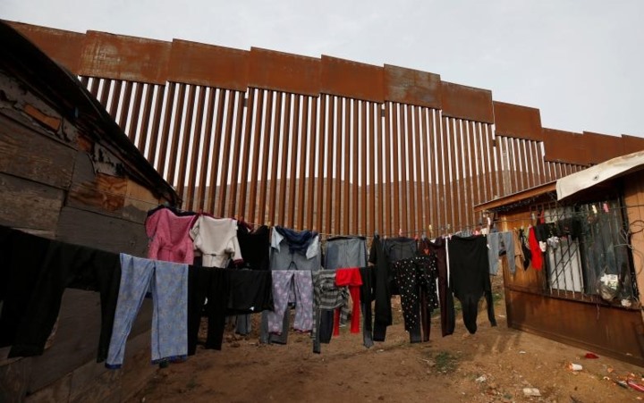 Những bộ quần áo treo trên dây phơi được nhìn thấy gần hàng rào biên giới giữa Mỹ và Tijuana, Mexico.