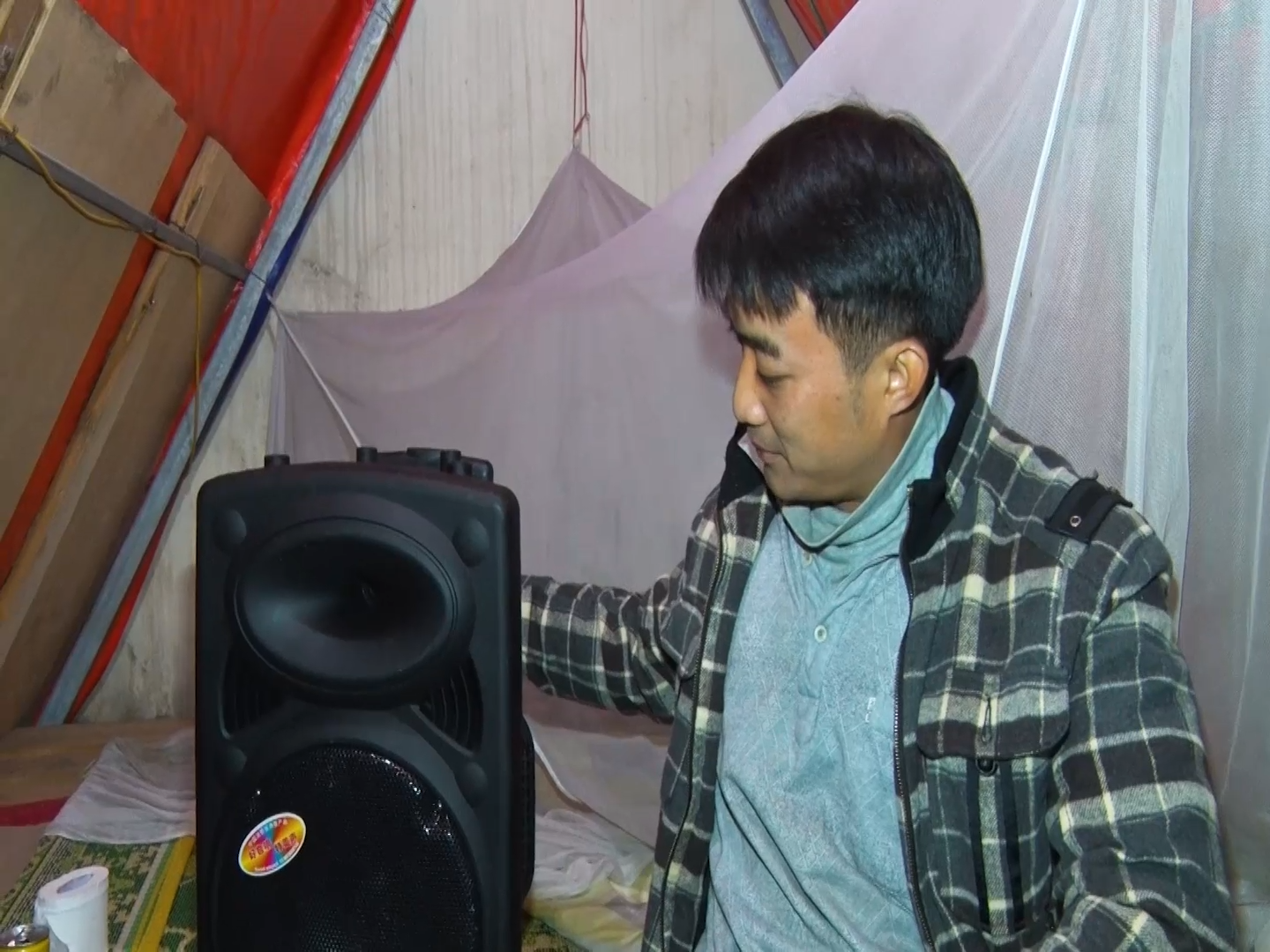 Anh Nguyễn Minh Tuấn bật nhạc để tạm quên đi cơn buồn ngủ mỗi khi phải làm việc thâu đêm để trông giữ vườn đào. 