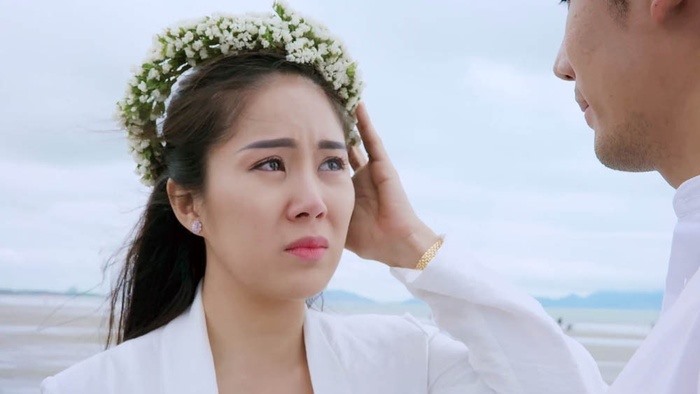 Kết thúc, cặp đôi mặc đồ trắng trao nhau nụ hôn bên bờ biển.