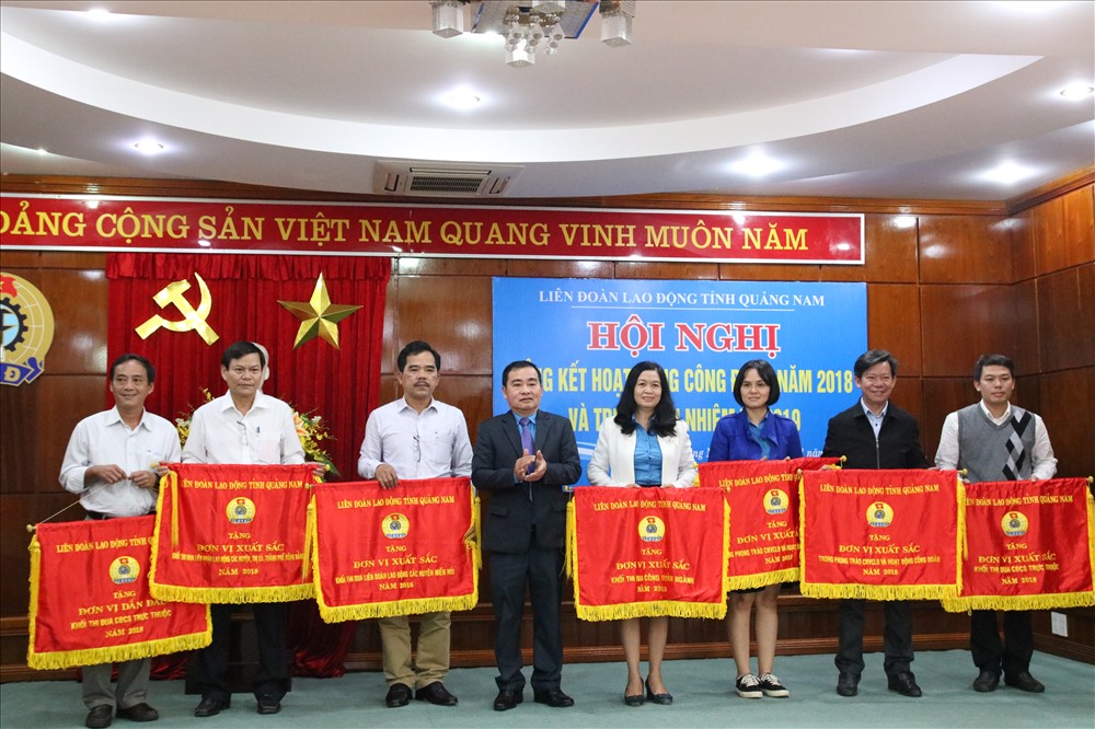 Ông Phan Xuân Quang - Chủ tịch LĐLĐ tỉnh Quảng Nam - tặng cờ thi đua cho các đơn vị xuất sắc. Ảnh: Đ.V