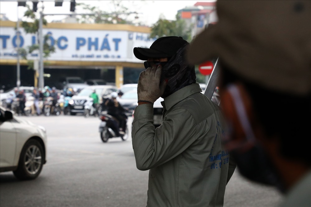 Các công nhân dùng máy chuyên dụng để cắt mặt đường nhựa, phân vị trí xén dải phân cách trên đường Nguyễn Xiển.