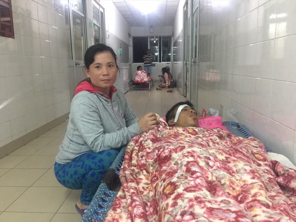 Nạn nhân Phạm Phước Lê đang được chị gái Phạm Thị Hồng chăm sóc.