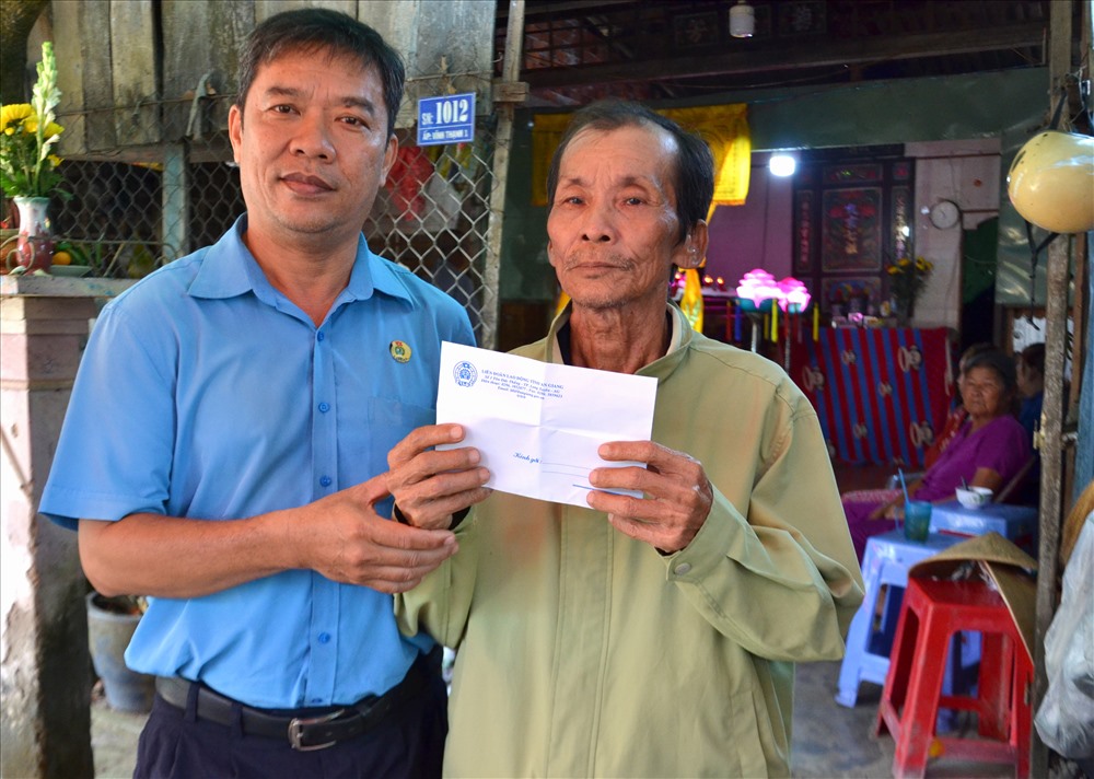 Ông Nguyễn Hữu Giang trao hỗ trợ cho đại diện gia đình anh Trần Quang Khải. Ảnh: Lục Tùng