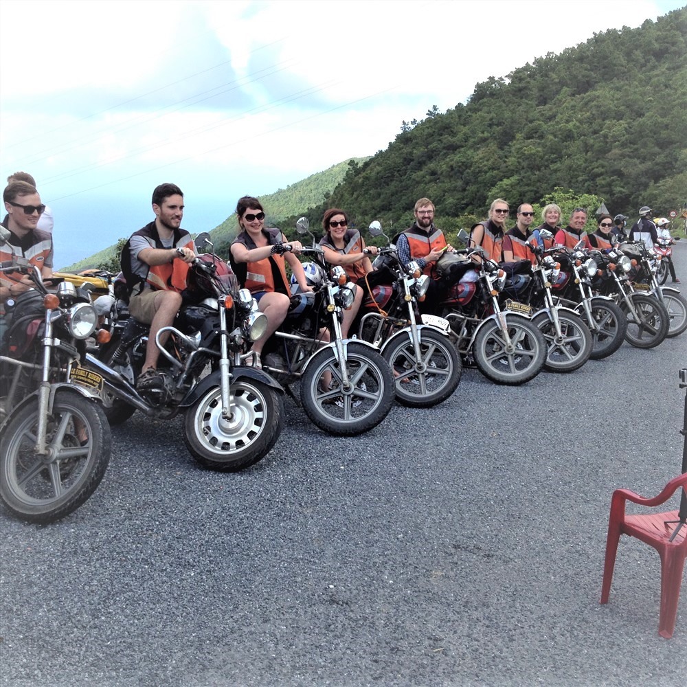 Đoàn khách du lịch nước ngoài chụp ảnh lưu niệm trên đèo Hải Vân trong một chuyến đi phượt bằng xe máy Master. Ảnh: Long Du