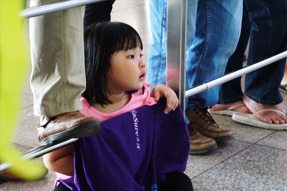 Một em nhỏ theo bố mẹ đến sân bay đón người thân.