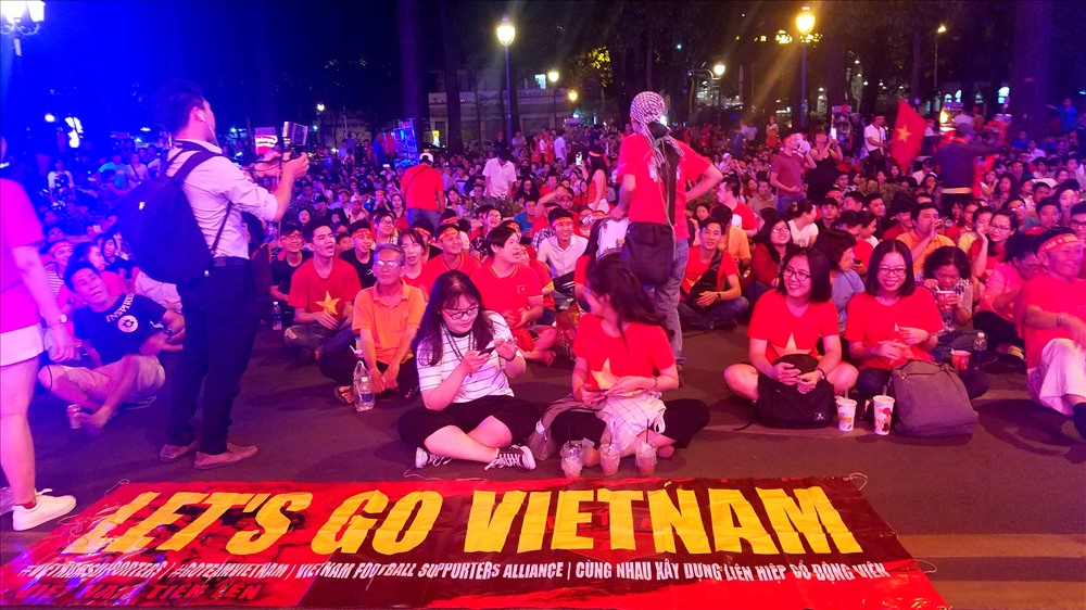 Những cổ động viên trẻ tuổi giúp nhau trang điểm bằng những tấm băng rôn “Việt Nam chiến thắng” trên đầu hay dán cờ vào hai bên má, chụp ảnh selfie trước giờ bóng lăn... 