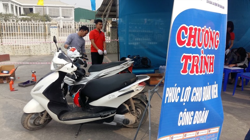 Thay dầu xe máy miễn phí cho công đoàn viên tại phiên chợ. Ảnh: Nguyễn Hùng