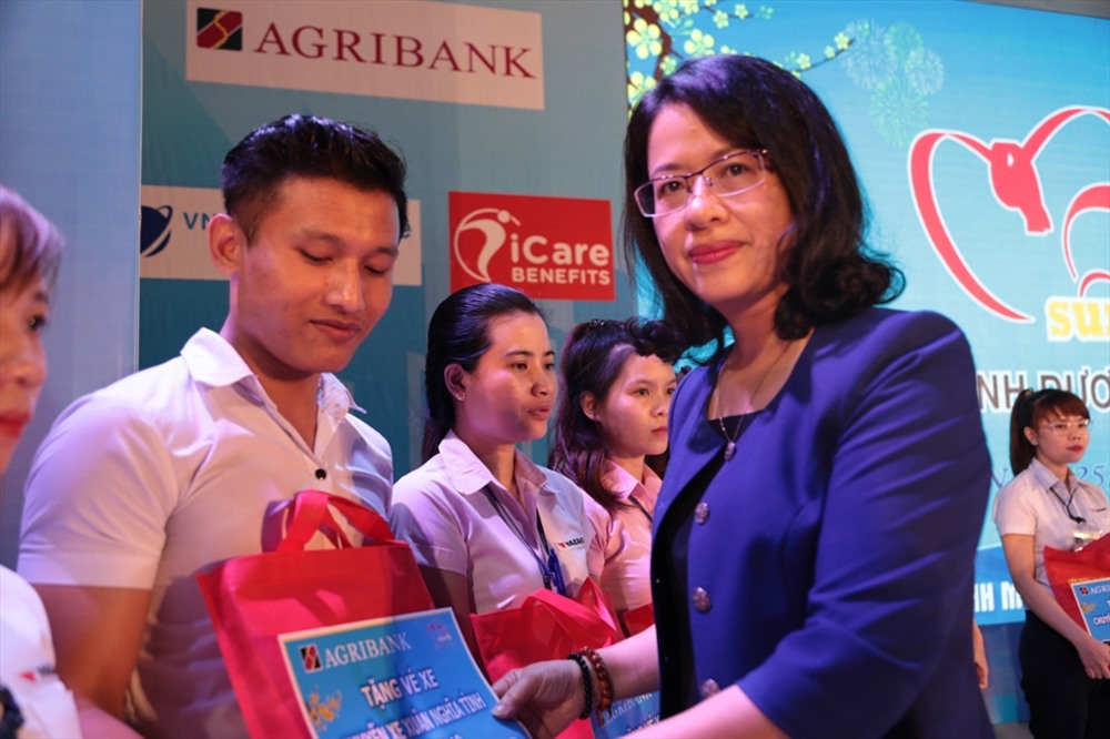 Bà Nguyễn Thị Phượng - Phó Tổng giám đốc Agribank - trao vé xe cho công nhân tại Tết sum vầy 2019 ở Bình Dương tối 25.1 - ảnh Trường Sơn