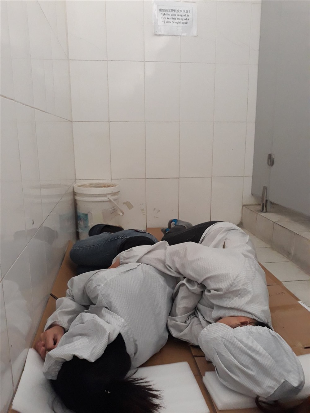 Công nhân tranh ngủ ngả lưng buổi trưa trong nhà vệ sinh Cty. Ảnh đoạt giải nhất cuộc thi.