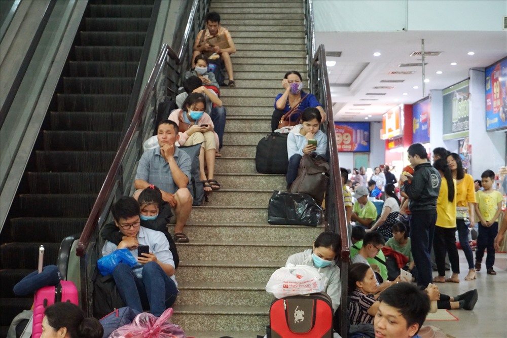 Tại ga Sài Gòn, hành khách tranh thủ ngồi chờ ở bất cứ chỗ nào có thể, từ cổng vào, sảnh ga cho đến lối đi cầu thang.