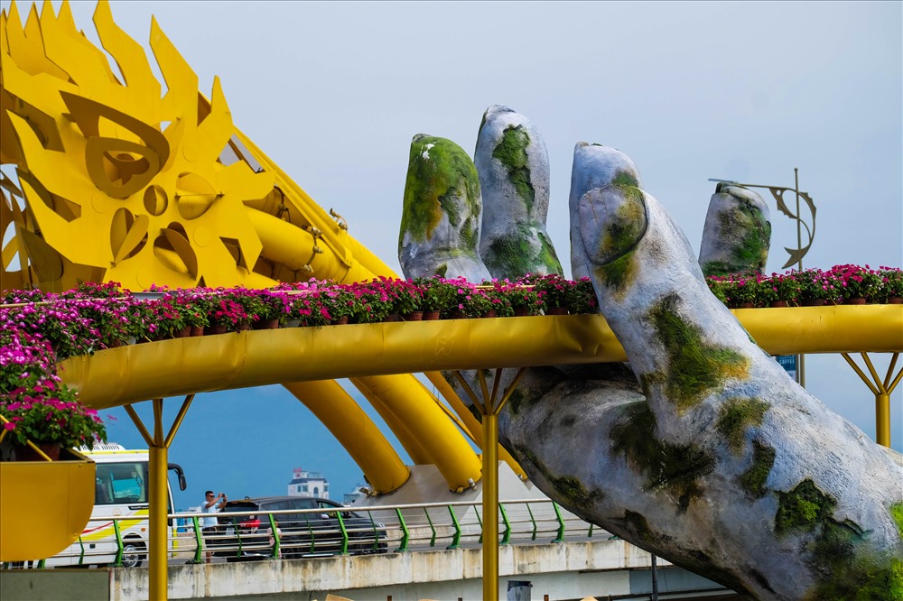 Mô hình Cầu Vàng có kích thước bằng 1/4 kích thước của cầu thật, được trang trí bằng hoa và cây xanh.