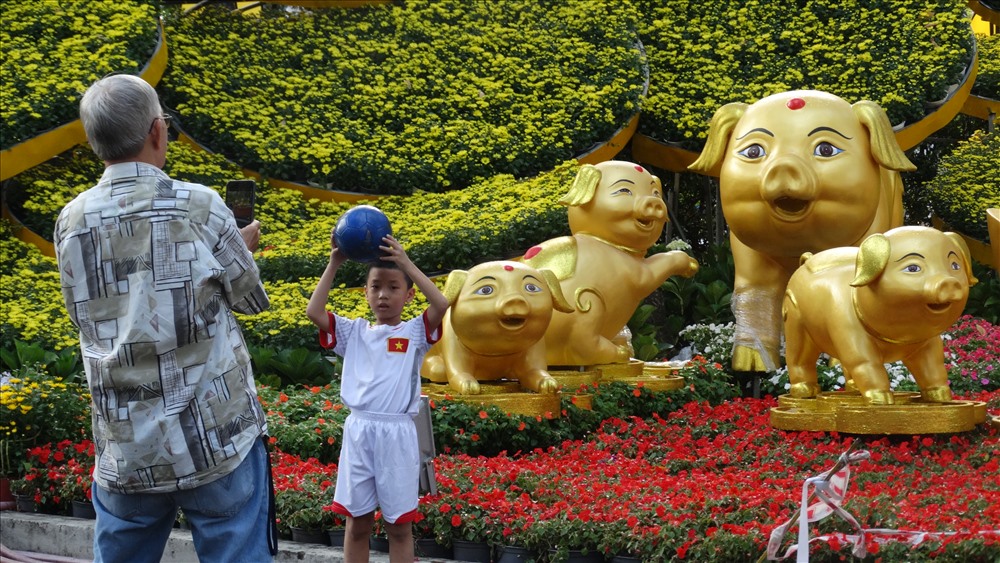Du khách chụp hình bên gia đình heo vàng sum vầy tại khu vực cổng chính đường Trương Định