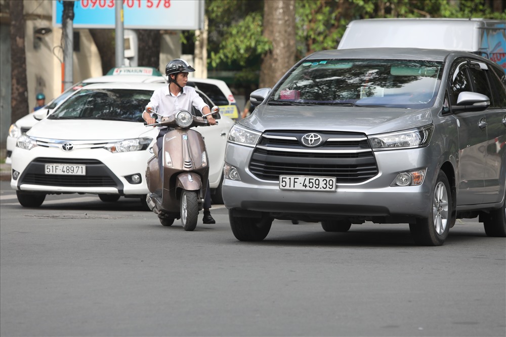 Một người đàn ông điều khiển xe máy tạt đầu ô tô khiến nhiều người phải rợn tóc gáy tại giao lộ Nguyễn Thị Minh Khai - Trương Định. Ảnh: Trường Sơn