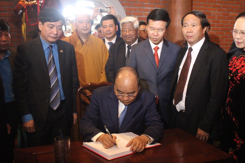 Thủ tướng Nguyễn Xuân Phúc viết lưu bút tại buổi lễ khánh thành Nhà tưởng niệm đồng chí Nguyễn Đức Cảnh. Ảnh: Phạm Đông