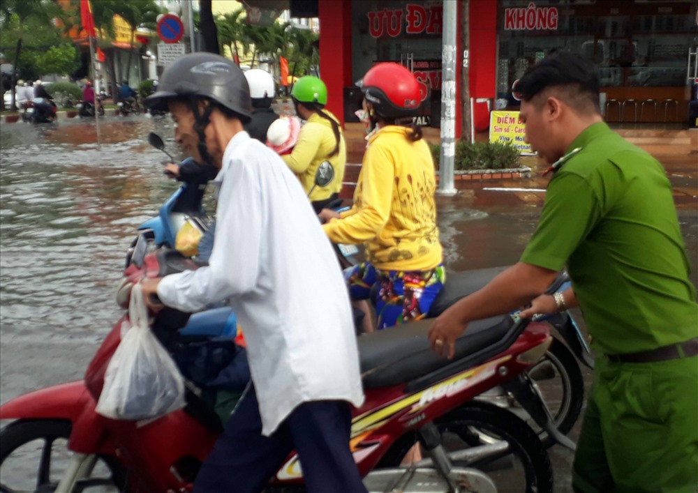 Công an Thành phố Bạc Liêu nhiệt tình giúp dân vượt qua đoạn ngập nước do ảnh hưởng bão số 1 (ảnh Nhật Hồ)