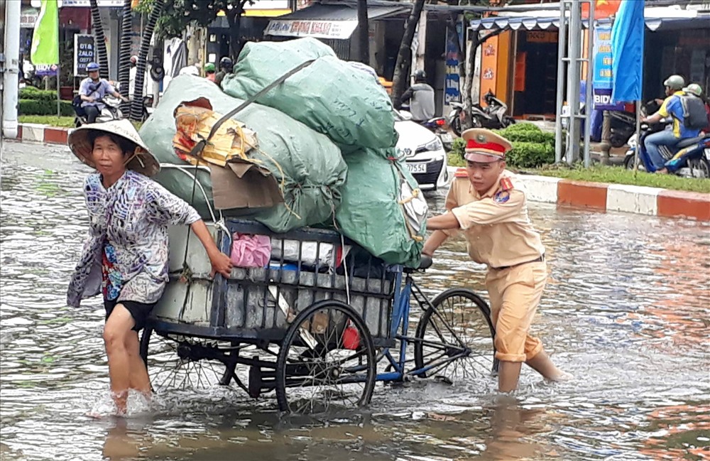 CSGT giúp dân vượt qua đoạn ngập sâu do ảnh hưởng bão số 1 (ảnh Nhật Hồ)