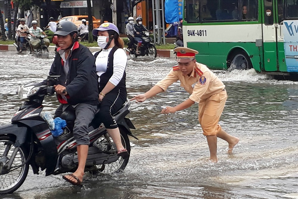 CSGT giúp người dân qua đoạn ngập nước do ảnh hưởng bão số 1 (ảnh Nhật Hồ)