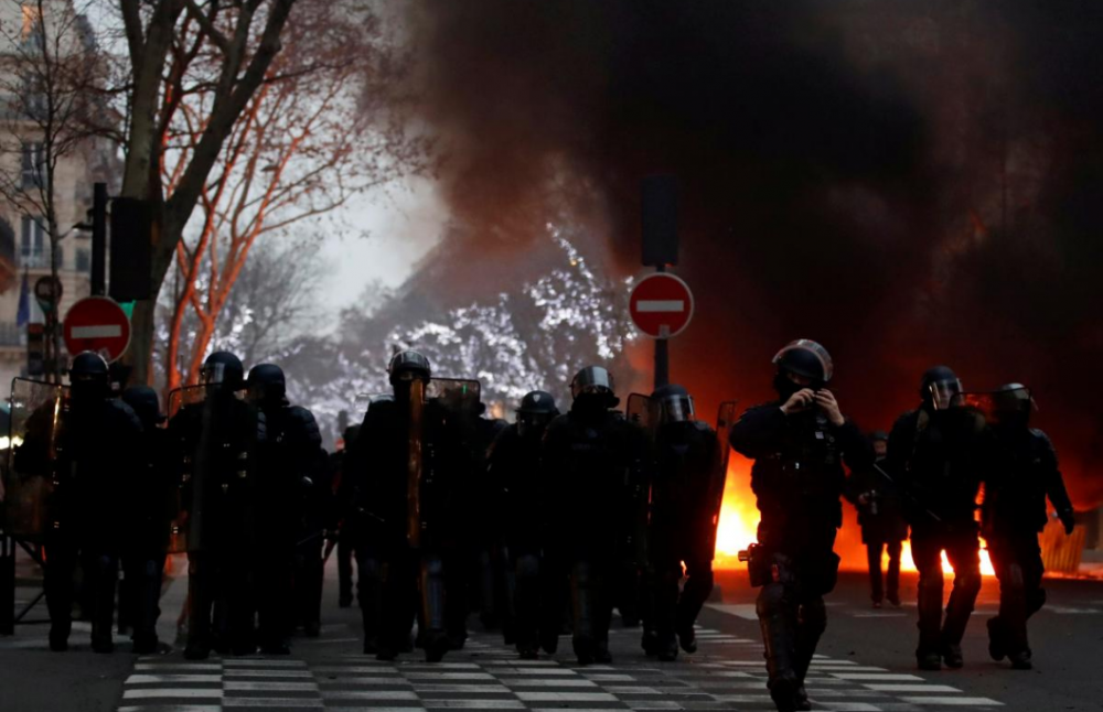 Trong những ngày cao điểm, xe bọc thép được huy động và cảnh sát được triển khai tại Paris để trấn áp đoàn người biểu tình. Ảnh: Reuters.