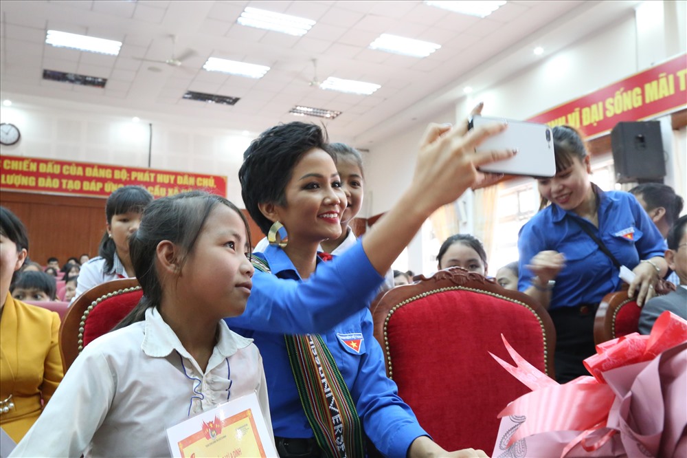 Hoa hậu H'Hen chụp ảnh lưu niệm với các em học sinh có hoàn cảnh khó khăn.