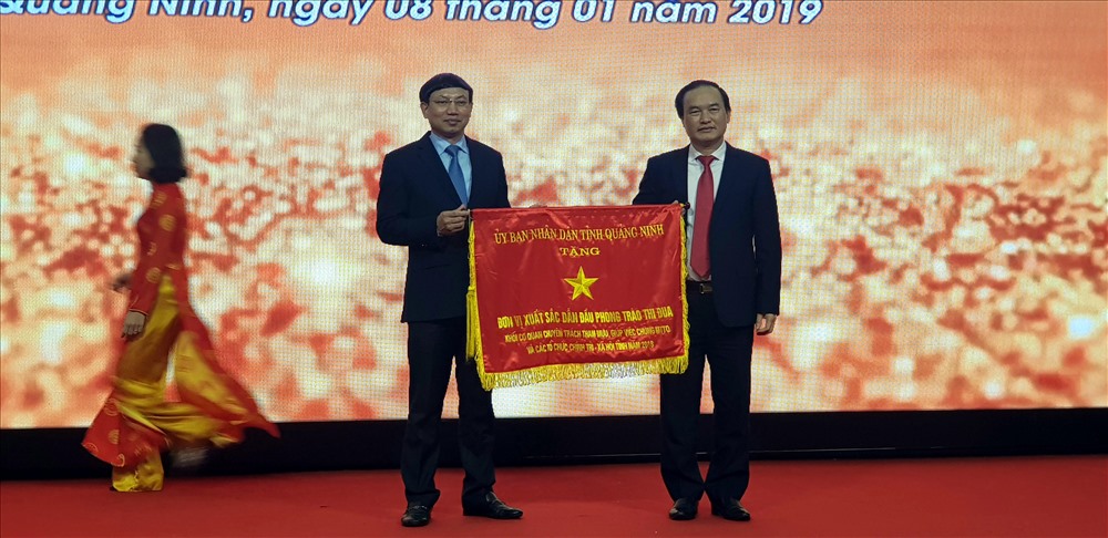Phó Bí thư Thường trực Tỉnh ủy Quảng Ninh, ông Nguyễn Xuân Ký trao tặng  cờ đơn vị dẫn đầu khối thi đua mặt trận và các tổ chức đoàn thể cho LĐLĐ Quảng Ninh. Ảnh: T.N.D