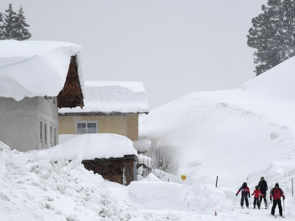 Những người trượt tuyết băng qua đường nơi tuyết rơi dày ở Filzmoos, Áo. Ảnh: Sky. 