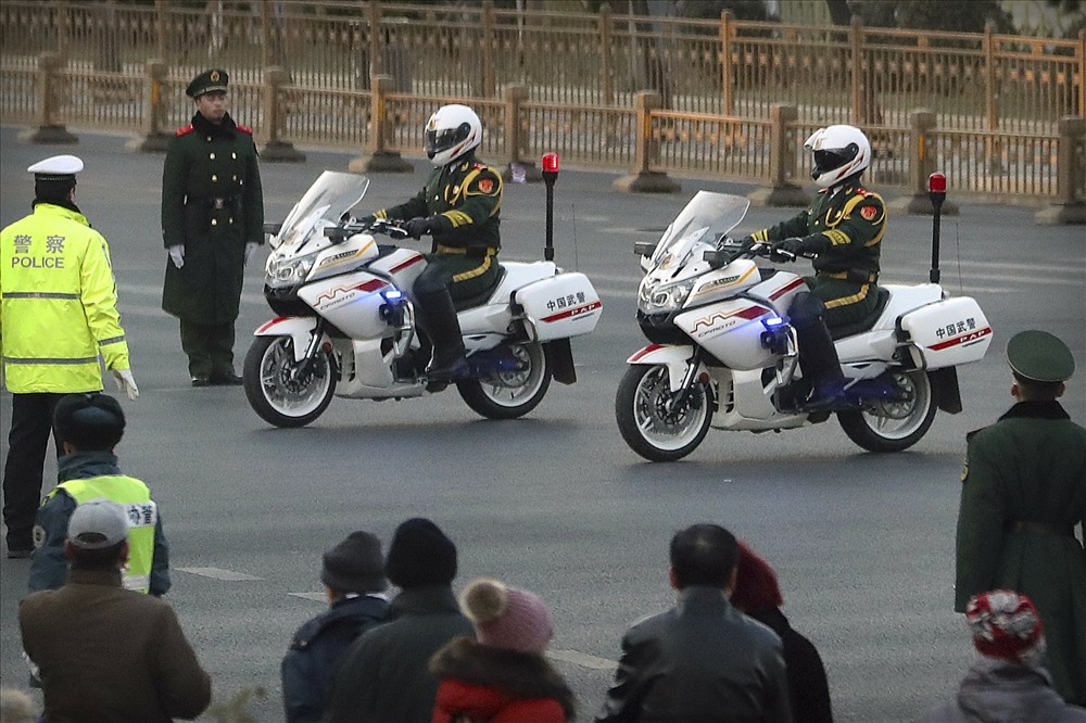 Cảnh sát bán quân sự Trung Quốc hộ tống nhà lãnh đạo Kim Jong-un. Ảnh: AP 