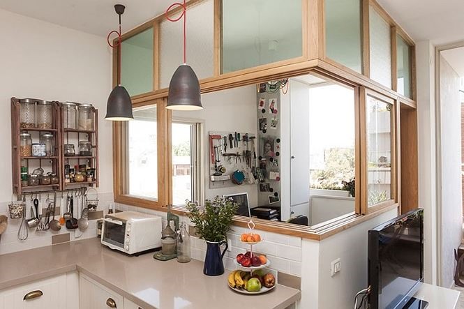 Bàn làm việc tận dụng khoảng hở giữa ban công và nhà bếp, nó ngăn cách với bếp bằng cửa kính để ngăn mùi thức ăn. 