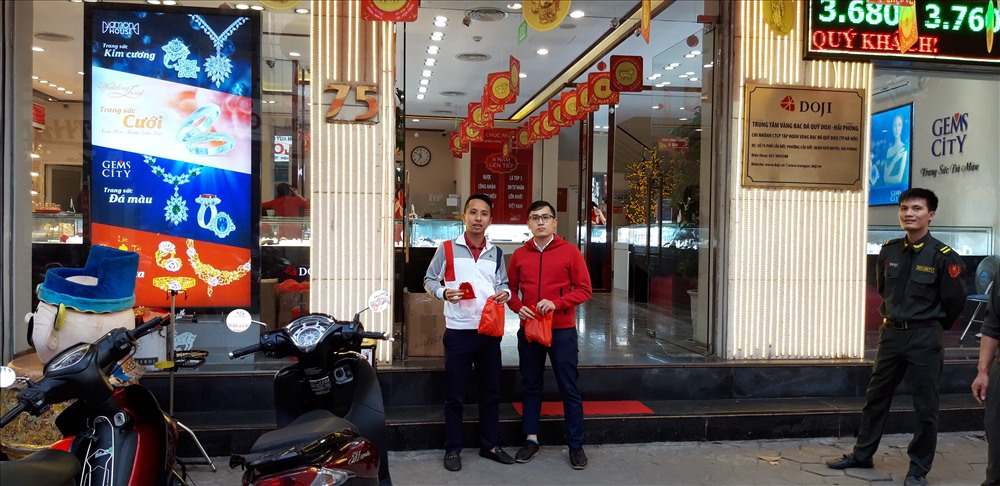 Anh Lê Minh Hoàng (SN 1989, ở phố Lán Bè) cùng em trai phấn khởi vì là khách hàng mua vàng sớm nhất, được cửa hàng tặng quà lưu niệm.