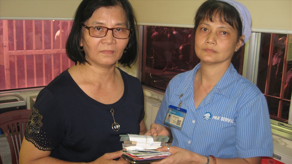 Chị Oanh (bên phải) trả lại tiền cho người bỏ quên. 
