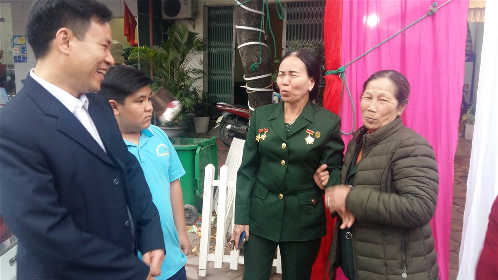 Bà Nguyễn Thị Thê (mặc quân phục) giới thiệu con trai duy nhất của bà với liệt sĩ Vũ Trọng Hiên với đồng đội cũ. Ảnh: Nguyễn Hùng