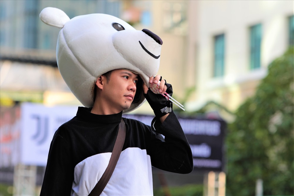Một bạn thanh niên làm nghề hóa thân thành gấu bông chụp hình lưu niêm trên phố đi bộ Nguyễn Huệ tranh thủ “lấy không khí“. Ảnh: Trường Sơn 