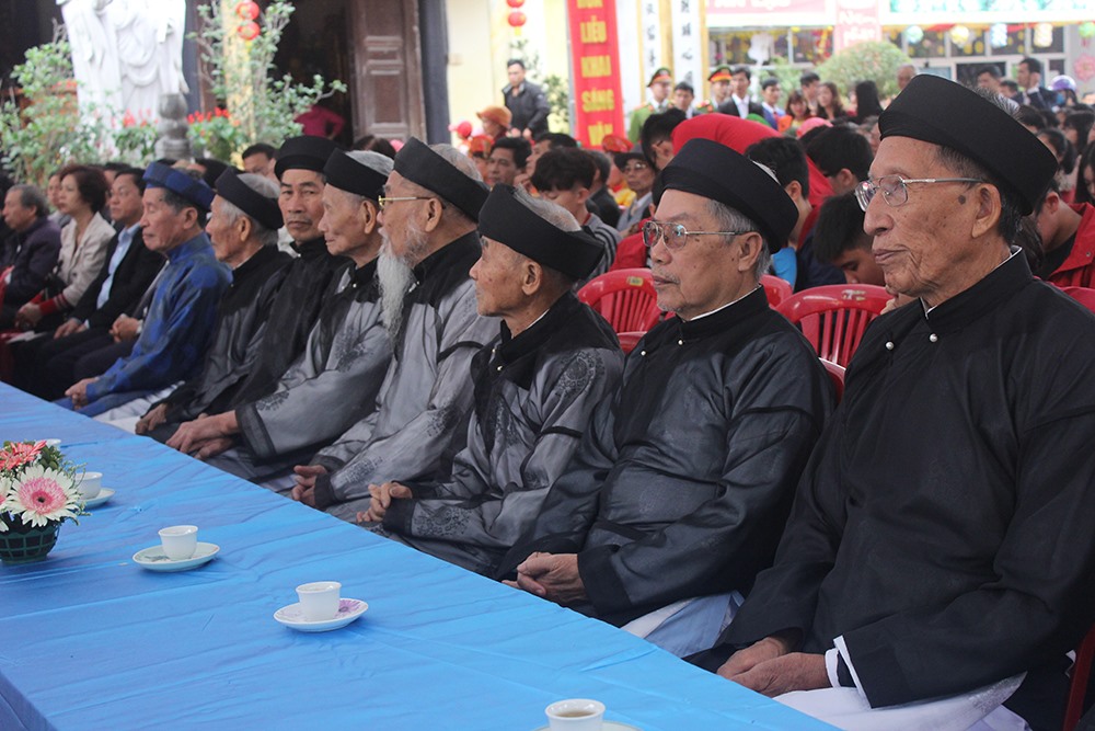 Các bậc cao niên trong làng lắng nghe và quan sát buổi lễ.