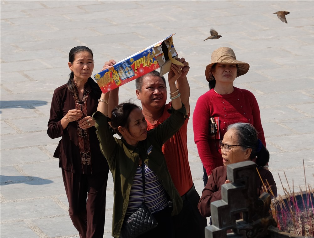 Người dân mang chim phóng sanh ở chùa Linh Ứng.