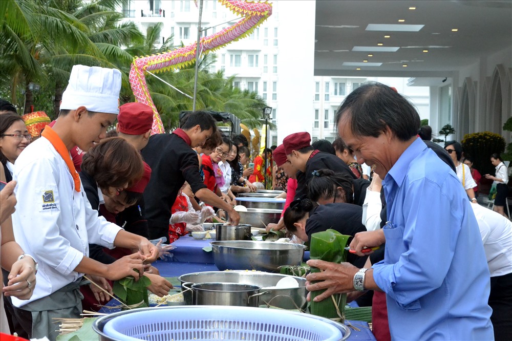 Người dân và du khách thích thú khi được tự tay gói những chiếc bánh tét cho ngày Tết. Ảnh: Châu Tường