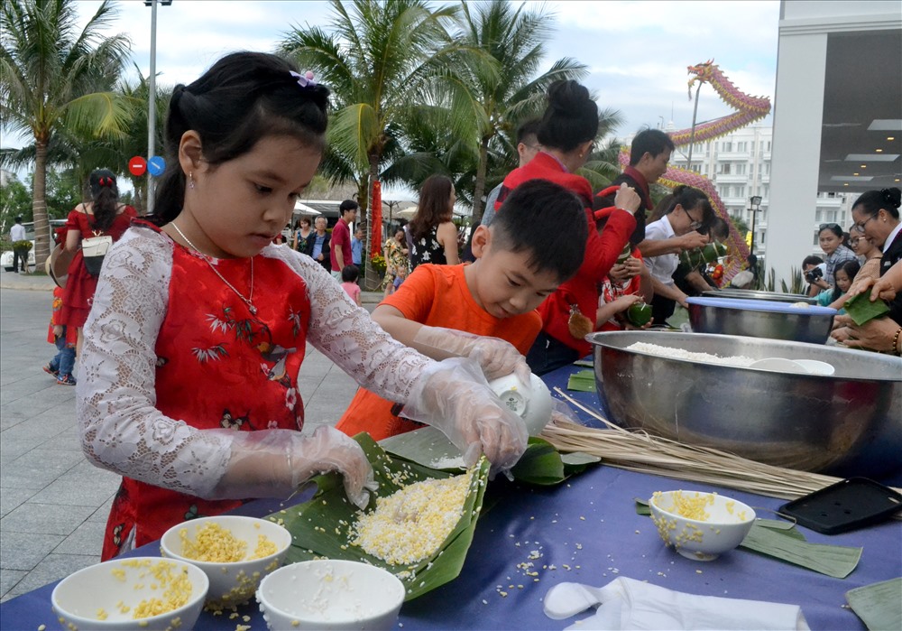 Các em nhỏ cũng rất vui khi lần đầu được gói bánh. Ảnh: Châu Tường