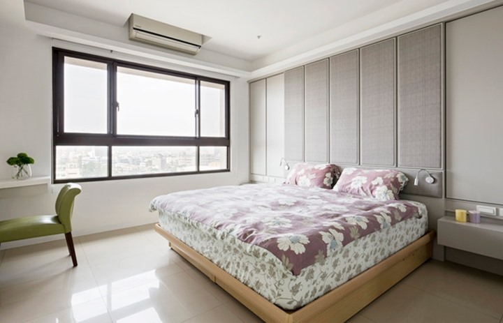 Phòng ngủ chính sơn tường màu trắng, kết hợp với tủ lưu trữ ẩn với đệm giường màu xám, cung cấp khu vực lưu trữ rộng rãi cho chủ nhân. 