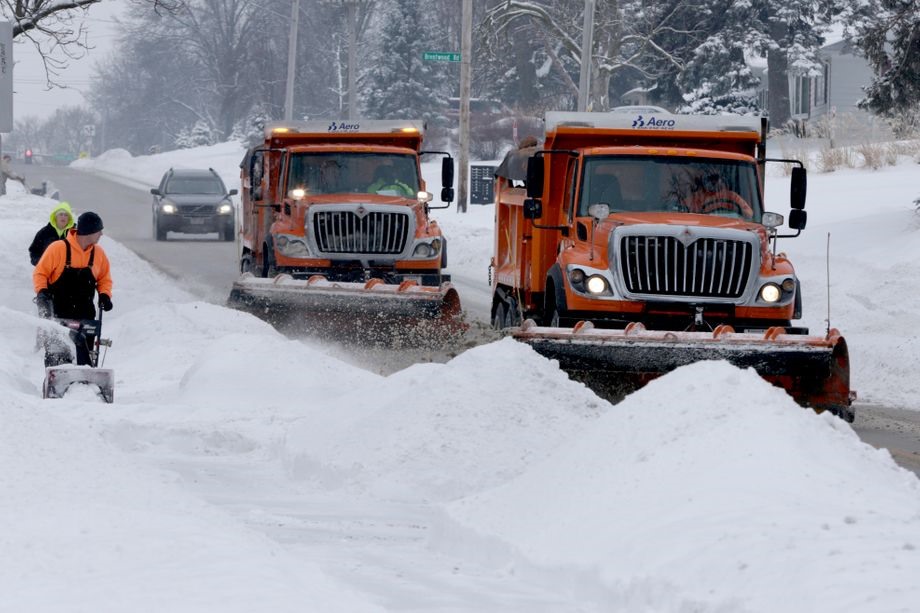 Người dân và máy xúc đang dọn tuyết trên đường phố ở Omaha.