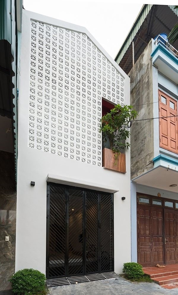 Mặt tiền ngôi nhà nổi bật với thiết kế gạch bông gió, loại gạch thường được dùng phổ biến tại Việt Nam trong những năm 1980 và 1990. 