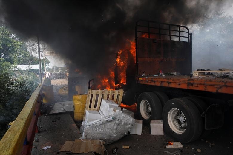 2 xe viện trợ  thực phẩm và thuốc men  bị chặn lại và vẫn nằm trên phần lãnh thổ Colombia. Những đối tượng này đã tự phóng hỏa 2 chiếc xe. Ảnh: Reuters.