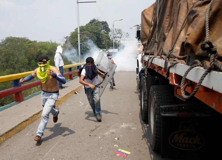 Binh lính Venezuela bắn hơi cay vào những người biểu tình tức giận vì không thể băng qua Colombia. Ảnh: Reuters.