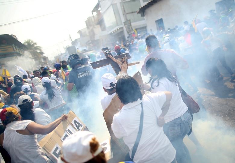 Binh lính Venezuela bắn hơi cay vào những người biểu tình tức giận vì không thể băng qua Colombia. Ảnh: Reuters.