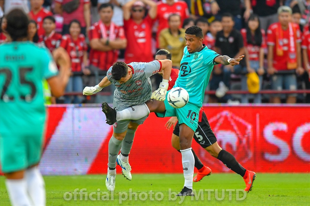 Văn Lâm dùng đầu cản phá bóng ở tình huống va chạm với tiền đạo Adnan Orahovac bên phía đối thủ. Ảnh Muangthong United