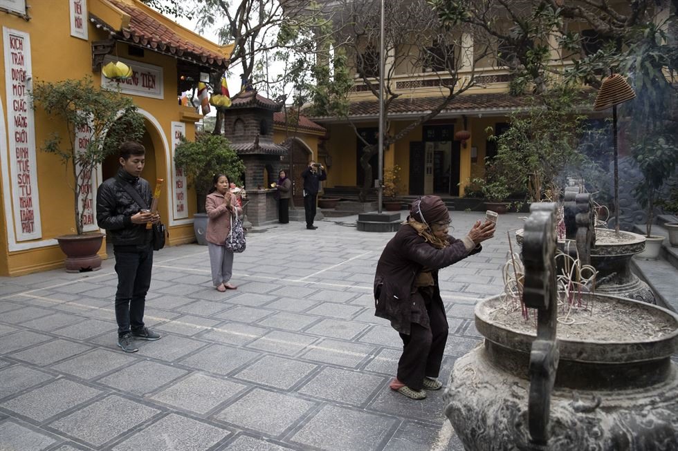 Du khách đến chùa Quán Sứ, Hà Nội cầu nguyện vào ngày 25.2. Công trình được xây dựng vào thế kỷ 15 để tiếp đón các đại sứ nước ngoài tới Hà Nội và hiện là trụ sở của Giáo hội Phật giáo Việt Nam. Ngôi đền được cải tạo vào năm 1822 để người dân địa phương có thể đến lễ bái tại đây. Ảnh: Korea Times. 
