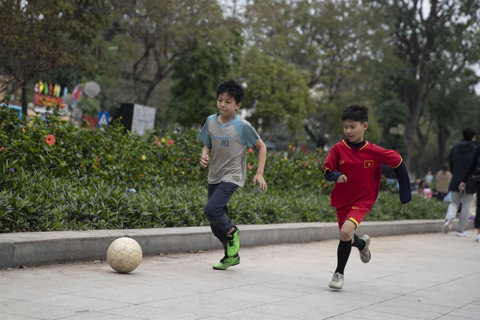 Trẻ em chơi bóng đá tại Công viên Thống Nhất, còn được gọi là Công viên Lenin, ở quận Ba Đình của Hà Nội vào ngày 24.2. Ảnh: Korea Times. 