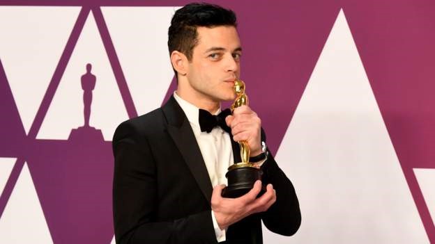 Khi lui vào hậu trường, Rami Malek đã có màn ăn mừng, hôn tượng vàng Oscars. Ảnh: CNN. 